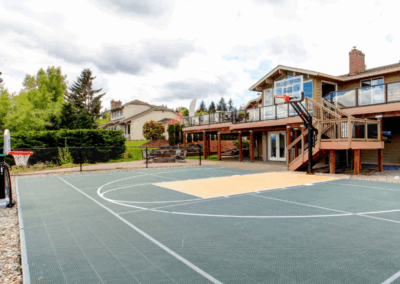 Green and Orange Half Basketball Court with House and Balcony on Cloudy Day
