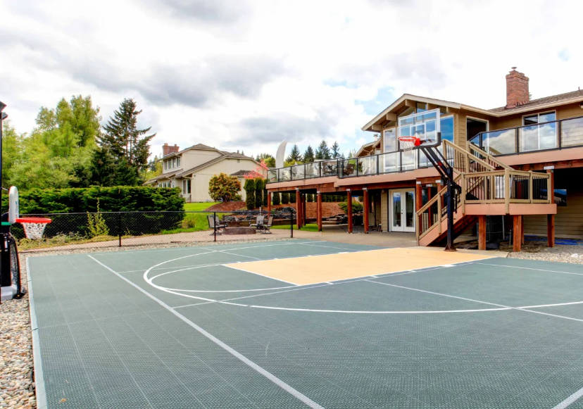 Green and Orange Half Basketball Court with House and Balcony on Cloudy Day