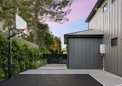 Space Utilised Basketball Court with Grey House and Green Trees and Garden