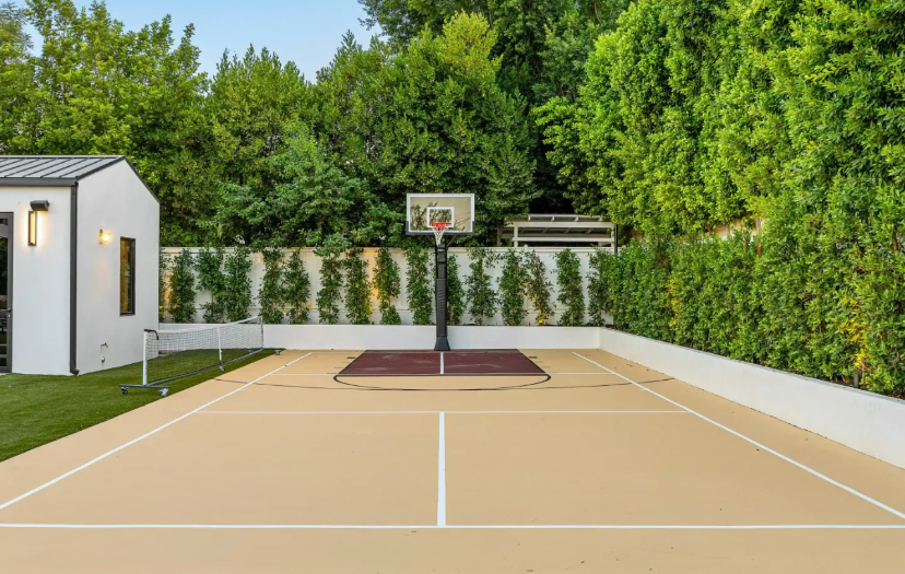 Basketball and Pickleball Court in Backyard with Green Trees in Background