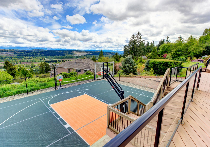 Deck with a Green and Orange Half Basketball Court Below with Incredible View of Mountains on Cloudy Day