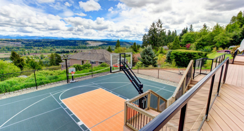 Deck with a Green and Orange Half Basketball Court Below with Incredible View of Mountains on Cloudy Day
