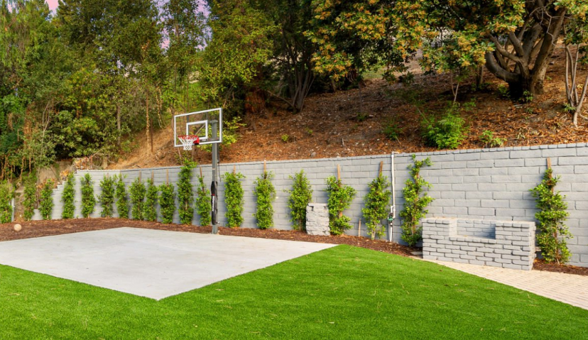 Basketball Court with Concrete Slab in Backyard with Green Grass and Garden