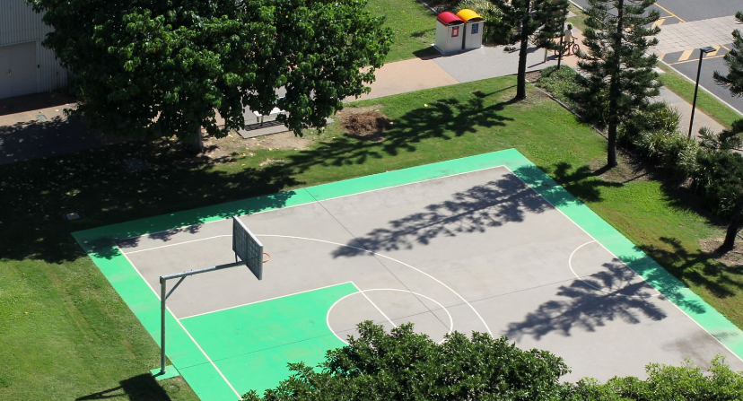 Green and Grey Half Basketball Court at a Public Park with Greenery Surrounding