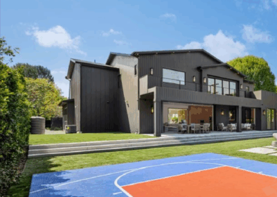 Modern House with a Blue and Orange Half Basketball Court in Backyard
